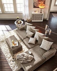 a living room filled with furniture on top of a hard wood floor covered in lots of pillows