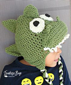 a child wearing a green crocheted hat with eyes