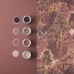 the wallpaper is made up of different types of flowers and plants, with three tins on each side