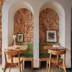 two tables and chairs in a room with wallpaper on the walls, one is green