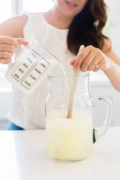 a woman is pouring milk into a pitcher