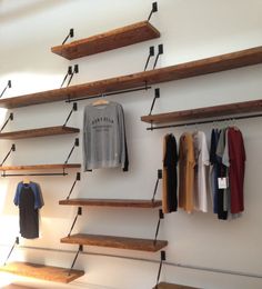 some wooden shelves with clothes hanging on them