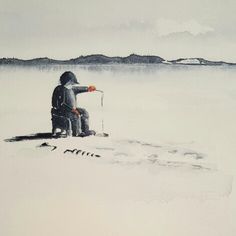 a man sitting on top of a snow covered ground next to a lake with an orange object in his hand