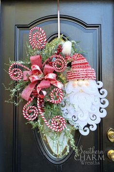 a christmas wreath with santa clause and candy canes hanging on the front door to say who's getting country down the days?