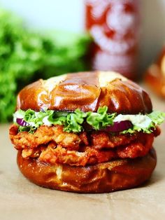 a chicken sandwich with lettuce and tomato sauce