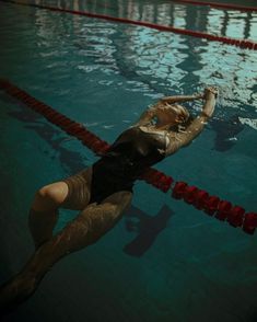 a woman is floating in the water with her arm extended and head tilted to the side