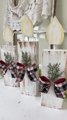 three wooden blocks decorated with bows and greenery