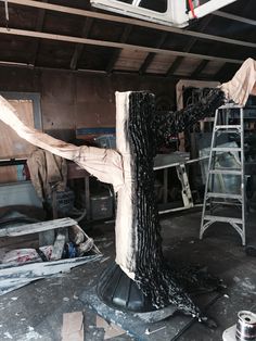 an artistic sculpture is being made in a workshop with many tools and materials around it