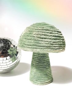 a disco ball sitting next to a green mushroom shaped object