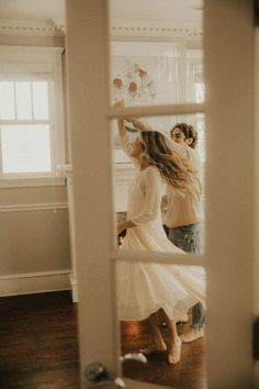 two people standing in front of a mirror