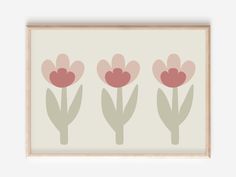 three pink tulips on a white background framed in a wooden frame with a light brown border