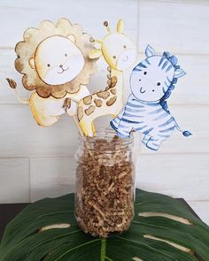 two giraffes and a zebra in a jar on a table with leaves