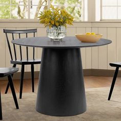 a black table with four chairs and a bowl of flowers on it in front of a window