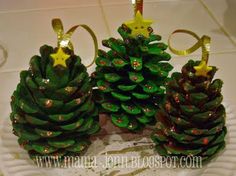 three pine cones sitting on top of a white plate covered in glitter and gold decorations