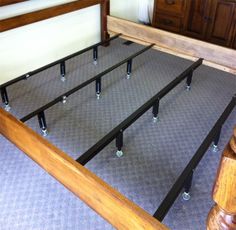 a wooden bed frame with four metal posts