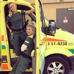 two women standing in the back of a yellow truck with their arms around each other