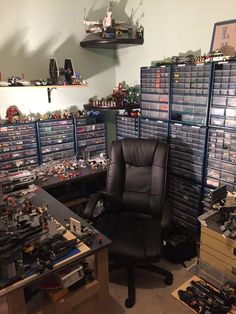 a black chair sitting in front of a desk filled with legos and other toys