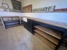 three wooden tables in a room with signs on the wall