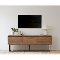 an entertainment center with a large flat screen tv mounted on it's sideboard