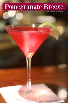 a close up of a drink in a glass on a table with the words pomegranate breeze