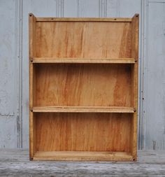 an empty wooden shelf against a white wall