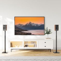 a flat screen tv mounted on the wall above a white entertainment center in a living room