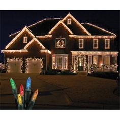 christmas lights are lit up in front of a house