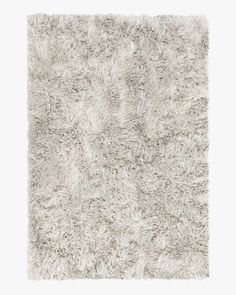 an area rug with shaggy white fur on the top and bottom, in grey tones