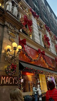 the macy's store is decorated for christmas with red and gold decorations on it