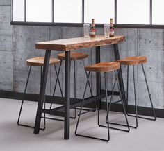 three stools and a table in front of a brick wall with large panoramic windows