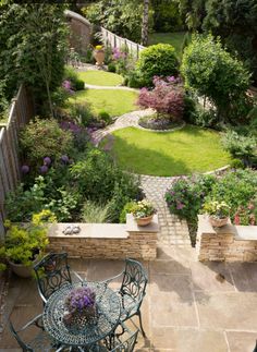 an outdoor patio with tables and chairs in the middle of it, surrounded by greenery