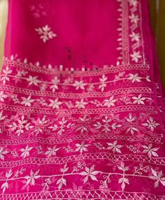 a pink table cloth with white flowers on it