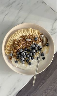 a bowl filled with yogurt, blueberries and granola