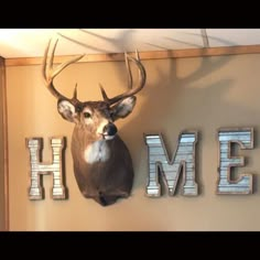 a deer head mounted to the side of a wall next to letters that spell home