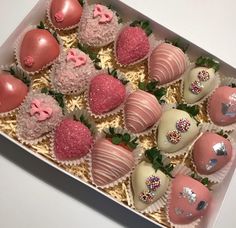 a box filled with chocolate covered strawberries on top of a table