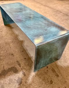 a metal bench sitting on top of a cement floor