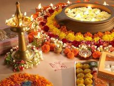 an arrangement of flowers, candles and sweets on a table in front of a plate