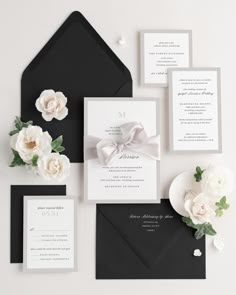 an elegant wedding suite with black envelopes and white flowers