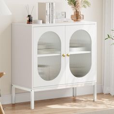 a white cabinet with two glass doors in a living room