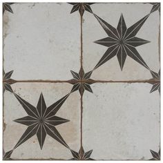 four black and white stars are on the floor in this tile pattern, which looks like they have been made from old tiles