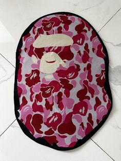 a pink and black bathing cap with a monkey on it's face in front of a white tile floor