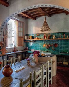 a kitchen with green tiles and wooden tables