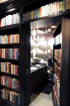 an open bookcase with many books on it in a room filled with lots of books