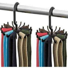 four different colors of rope hanging from a metal rod on a white background with black handles