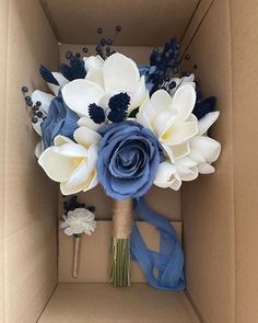 a blue and white bridal bouquet in a box