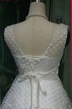 the back of a white dress with polka dots on it