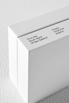 the front and back sides of a white box with labels on it, sitting on a plain surface