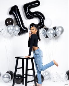 a woman standing on top of a stool in front of balloons and the number twenty five