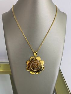 Embrace the enchantment of our 21K Gold Pendant, a delicate flower-shaped masterpiece. Imbued with an embedded horse rider insignia, it embodies a harmonious blend of elegance and adventurous spirit. Let this captivating pendant adorn your neckline, a symbol of exquisite taste and a timeless reminder of grace and daring. Traditional 14k Gold Medallion Necklace, Ceremonial Gold Necklace With Coin Pendant, Elegant Locket Necklace For Ceremonial Occasion, Elegant Coin Pendant Necklace For Ceremonial Use, Hallmarked Yellow Gold Pendant Medallion Necklace, Ceremonial Yellow Gold Coin Pendant Necklace, Hallmarked Yellow Gold Medallion Pendant Necklace, Elegant Yellow Gold Medallion Necklace With Large Pendant, Luxury Ceremonial Medallion Necklaces