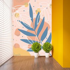 two potted plants sitting on top of a wooden floor next to a yellow wall